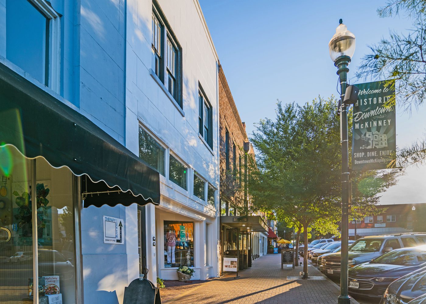 Storefronts and a lamppost banner along Historic Downtown McKinney.